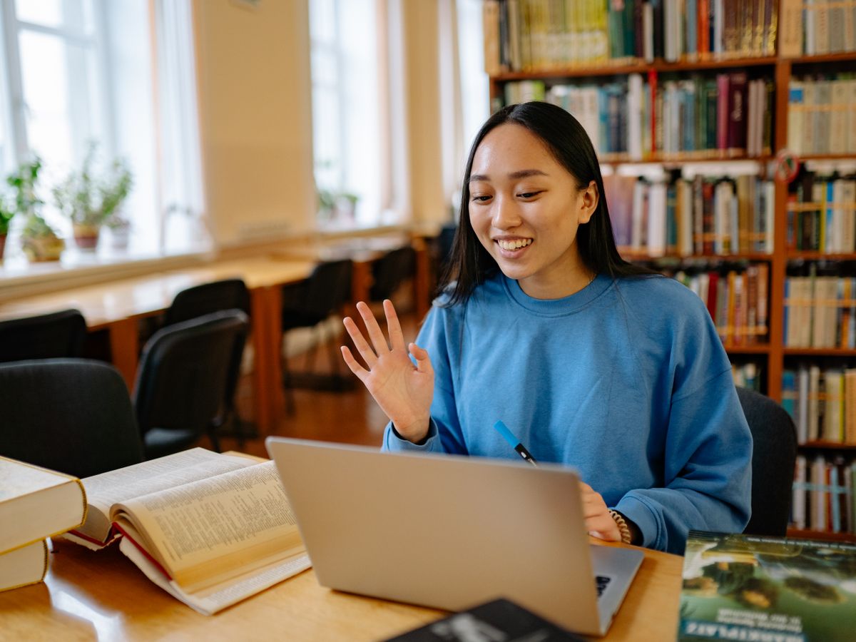 A student waving to her tutor at the start of an online lesson
