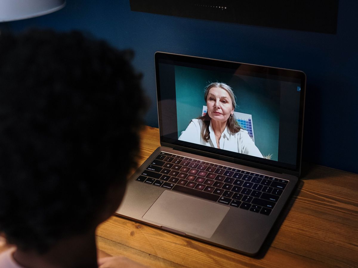 A student in an online lesson with their tutor on a laptop